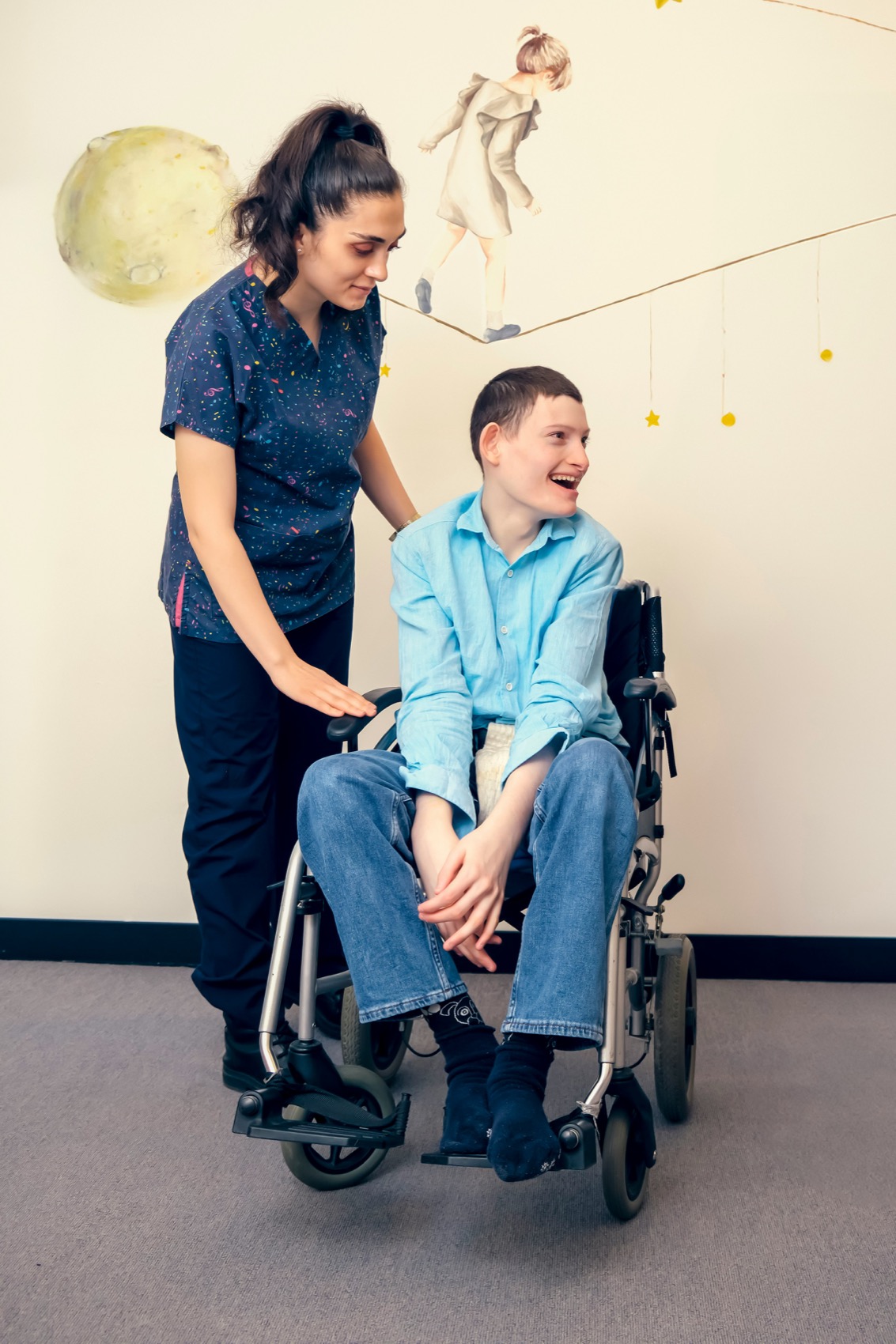 A caregiver supporting a smiling wheelchair user