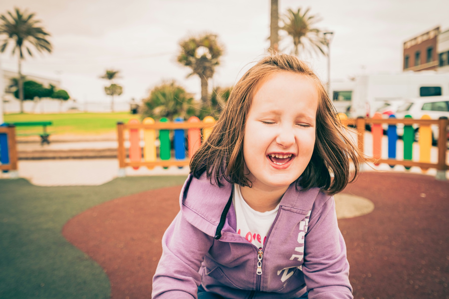 A child smiling on a playground