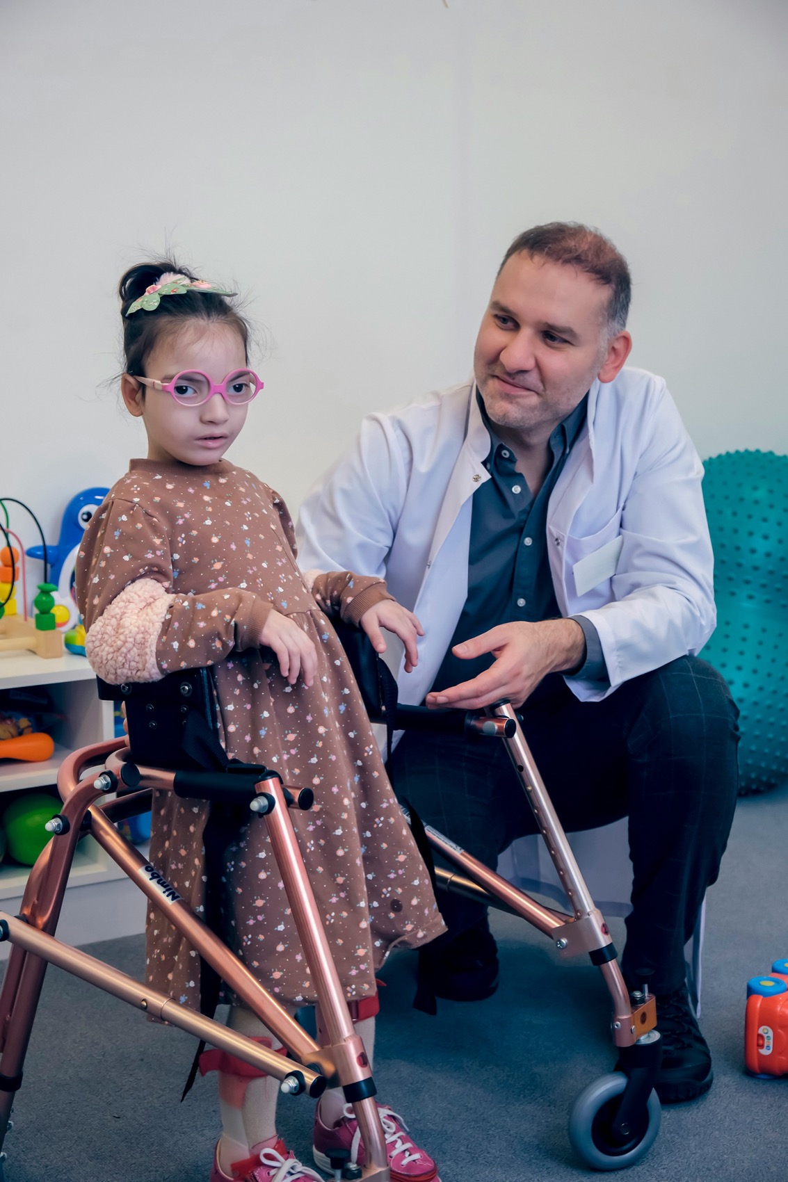 A child using a walker beside a clinician